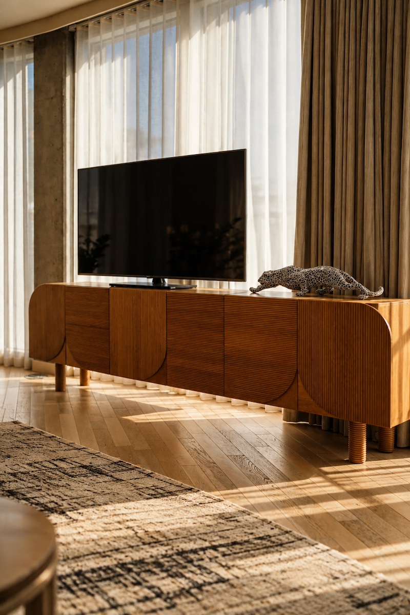 Sculptural wooden media console in a sunlit room